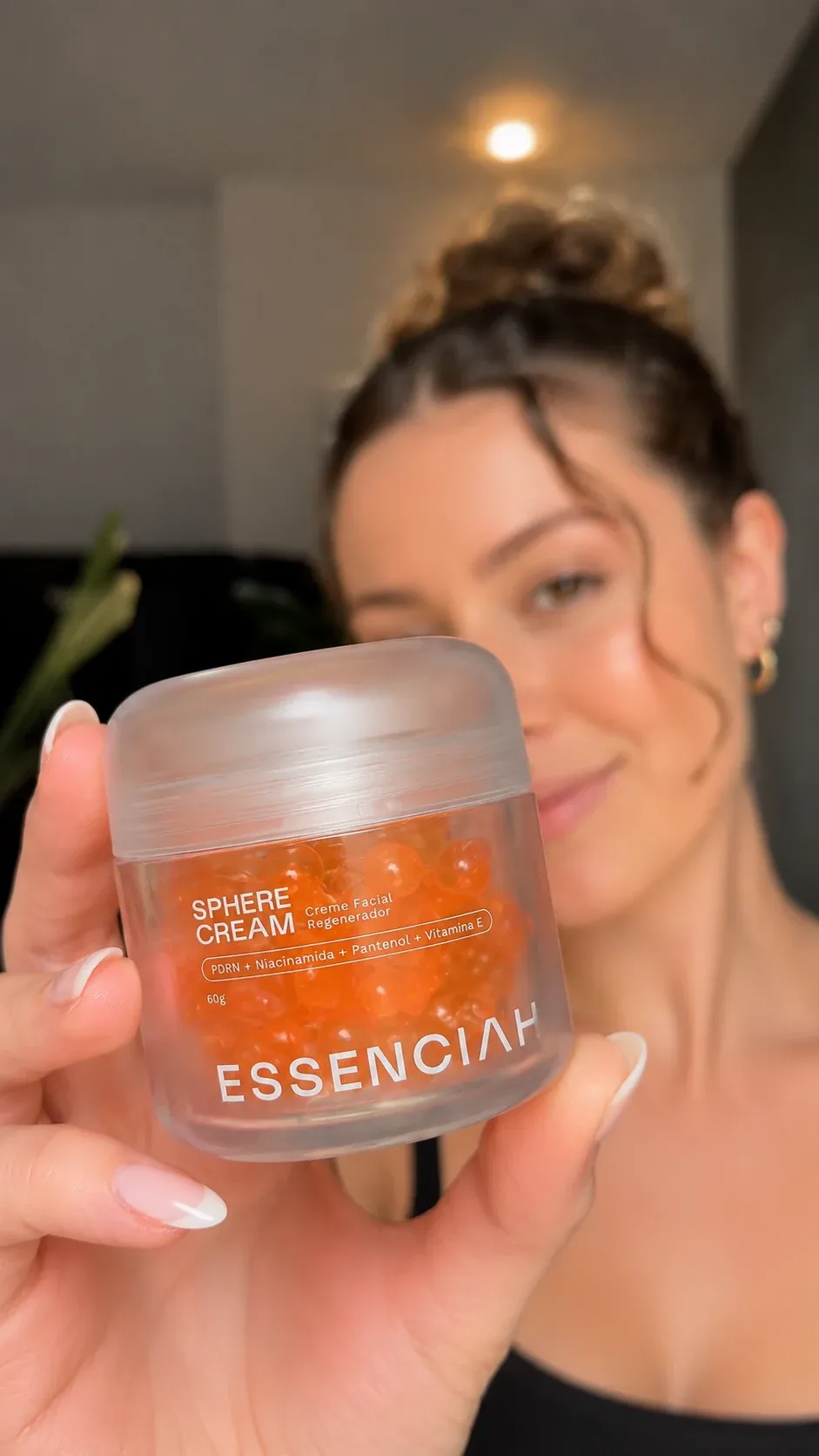 Mulher segurando o pote de Sphere Cream
