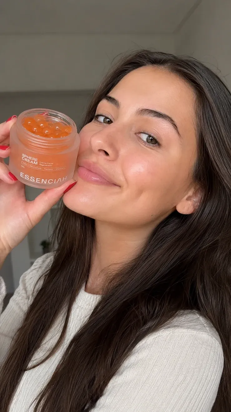 Cliente sorrindo com o pote de Sphere Cream