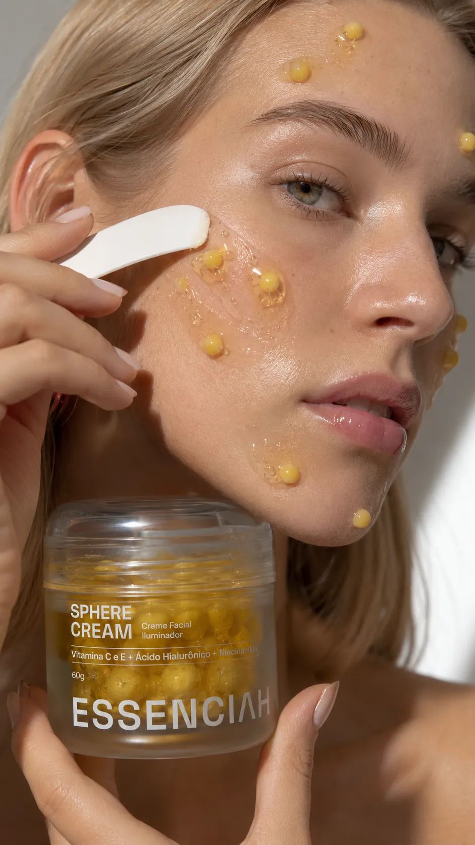 Mão segurando o pote de Sphere Cream no banheiro